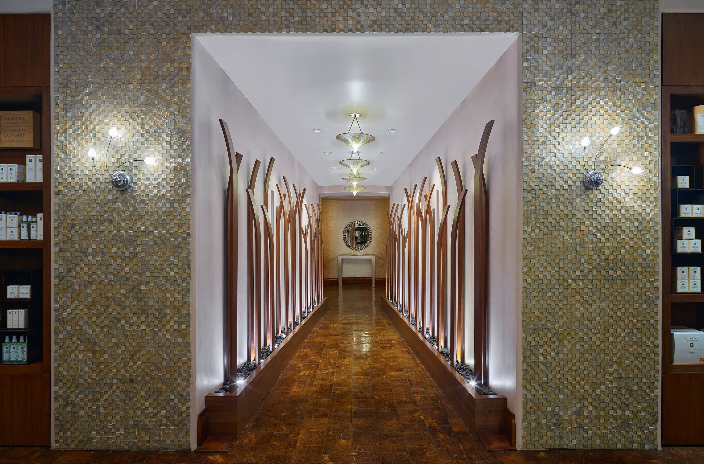 The spa corridor at The Arrabelle at Vail Square — sculpted aspen light, gold mosaic
